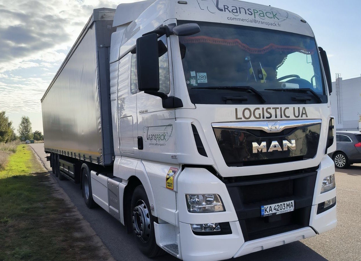 LOGISTIC UA white MAN truck with curtain-side trailer